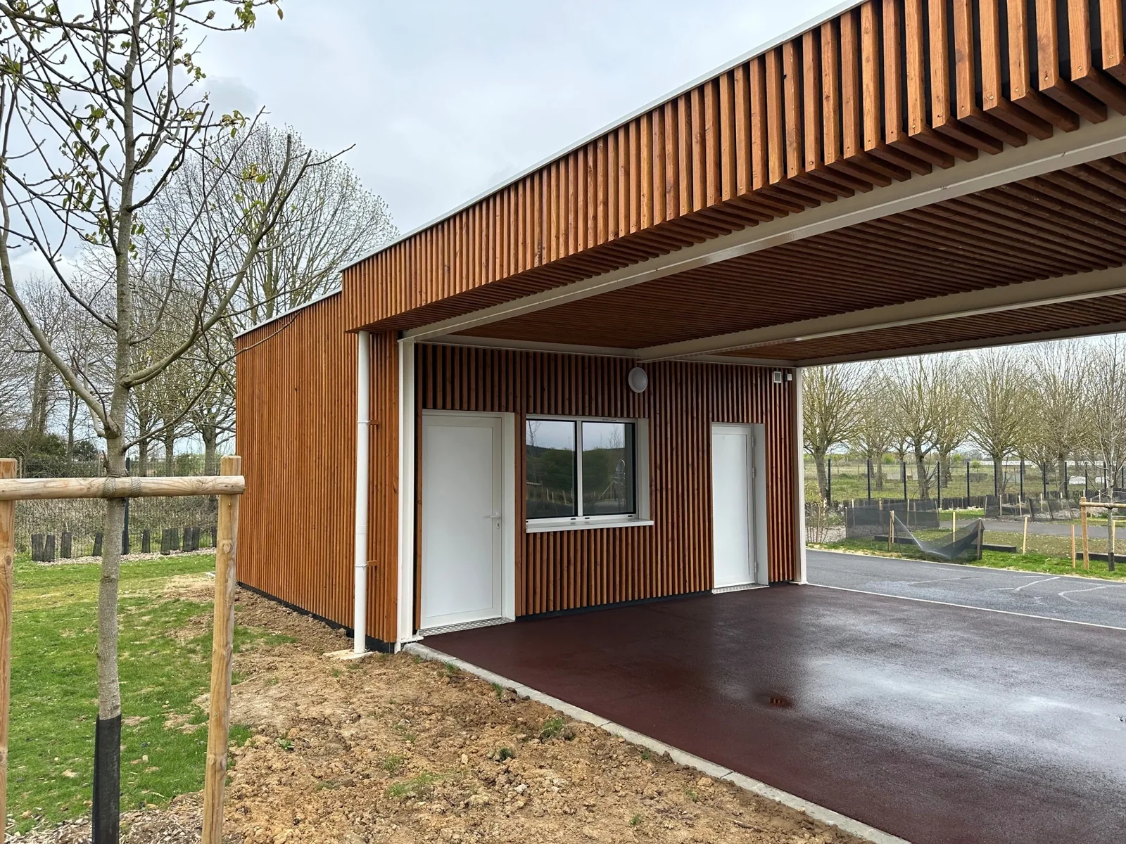 Façade en bois et espace couvert du bâtiment d’accueil modulaire à Lieusaint