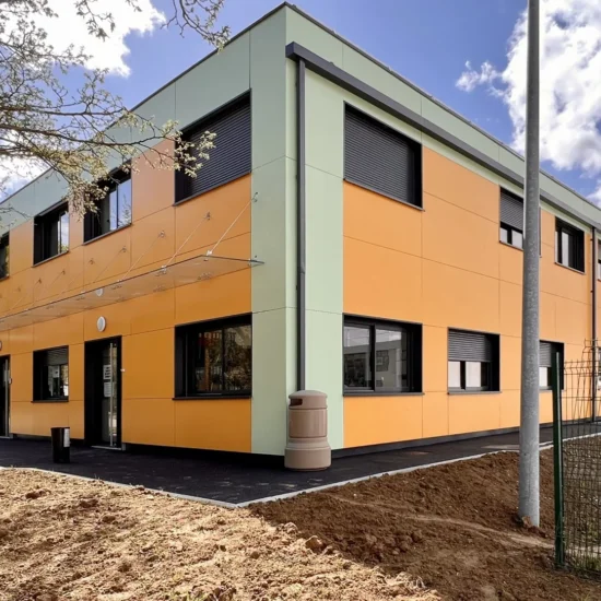 Centre technique municipal modulaire de Villepinte sur deux niveaux, avec façades orange et fenêtres noires