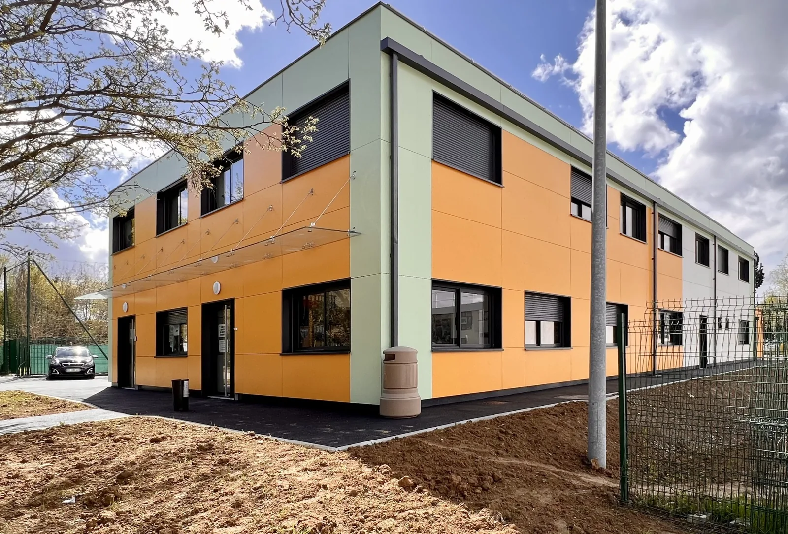 Centre technique municipal modulaire de Villepinte sur deux niveaux, avec façades orange et fenêtres noires