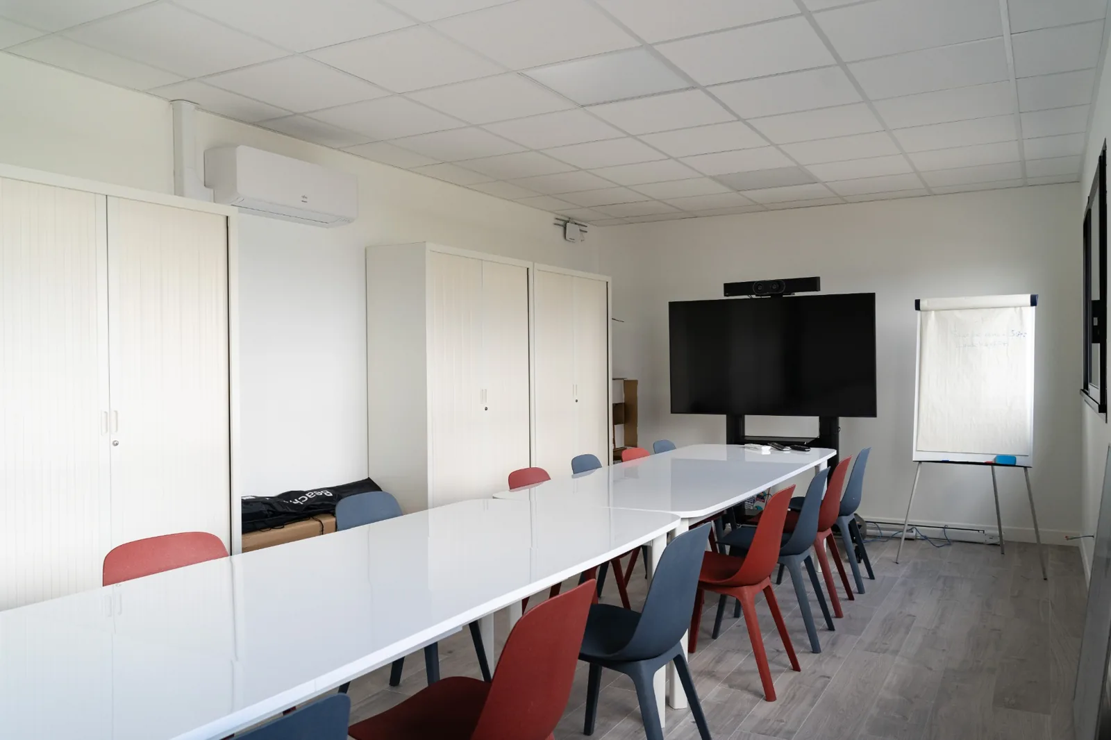 Salle de réunion aménagée avec grande table et écran dans les bureaux modulaires Leaseway