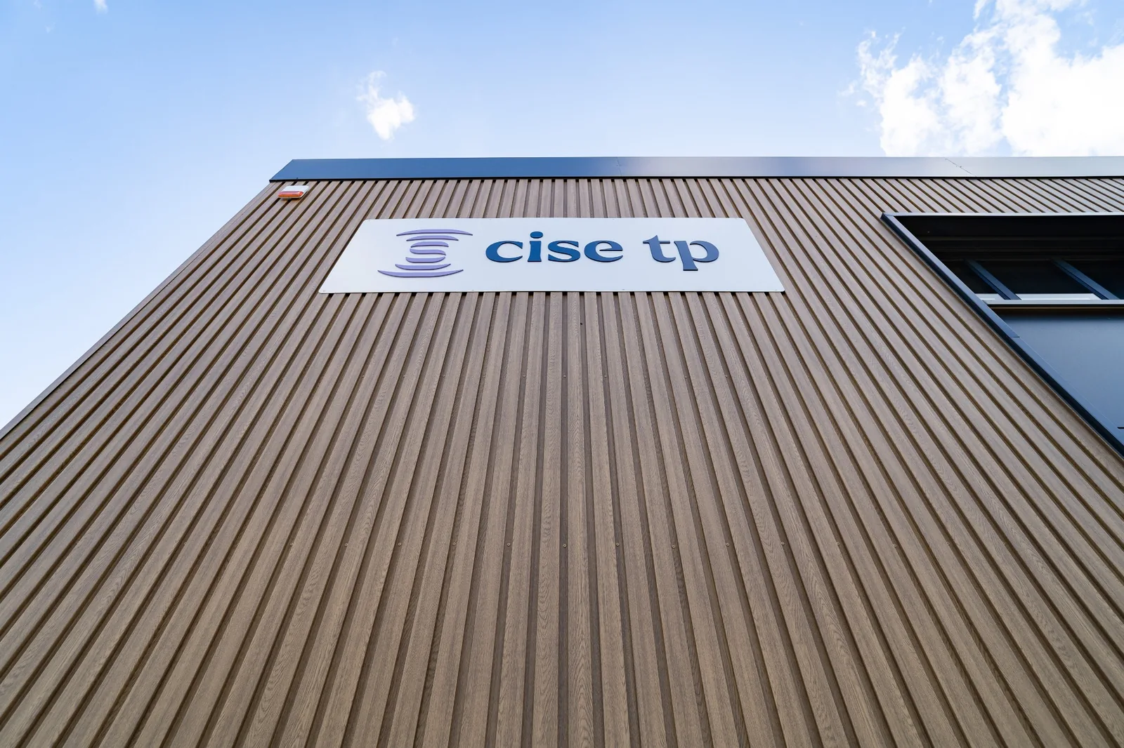 Bardage et enseigne Cise TP sur la façade des bureaux modulaires