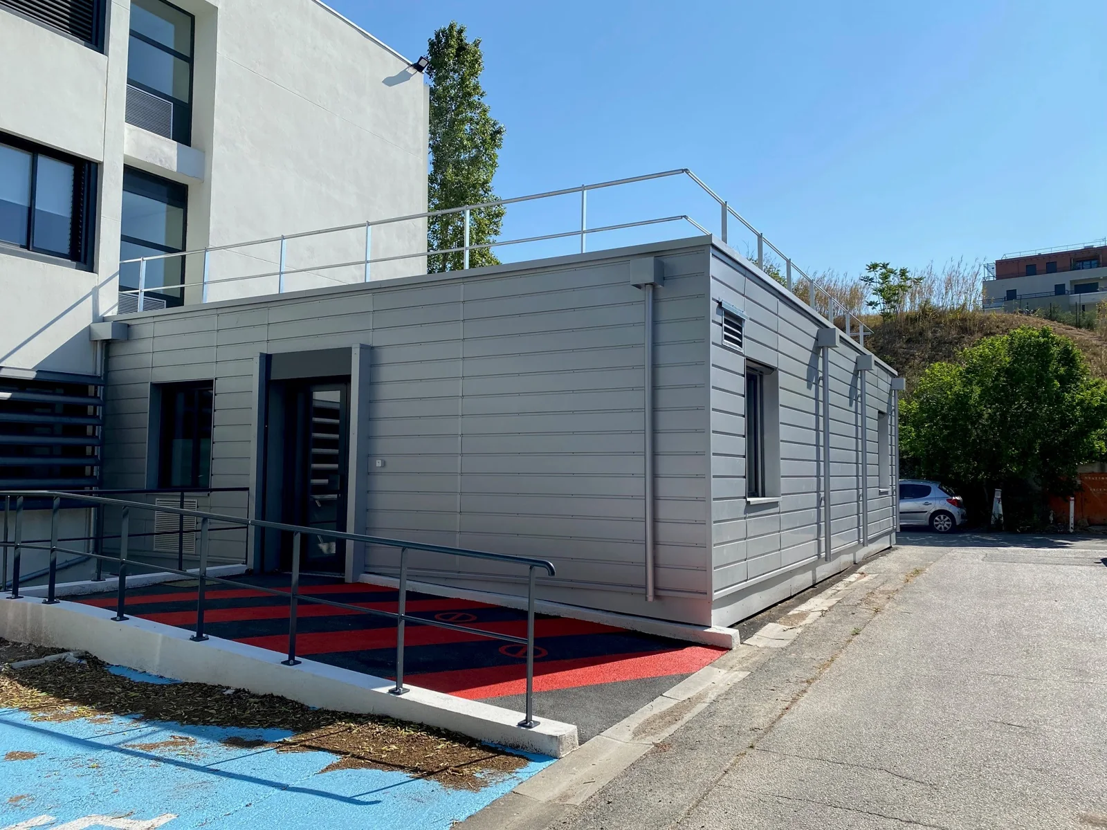 Façade grise et rampe d’accès de l’extension modulaire du service d’odontologie de l’AP-HM à l’hôpital de la Timone