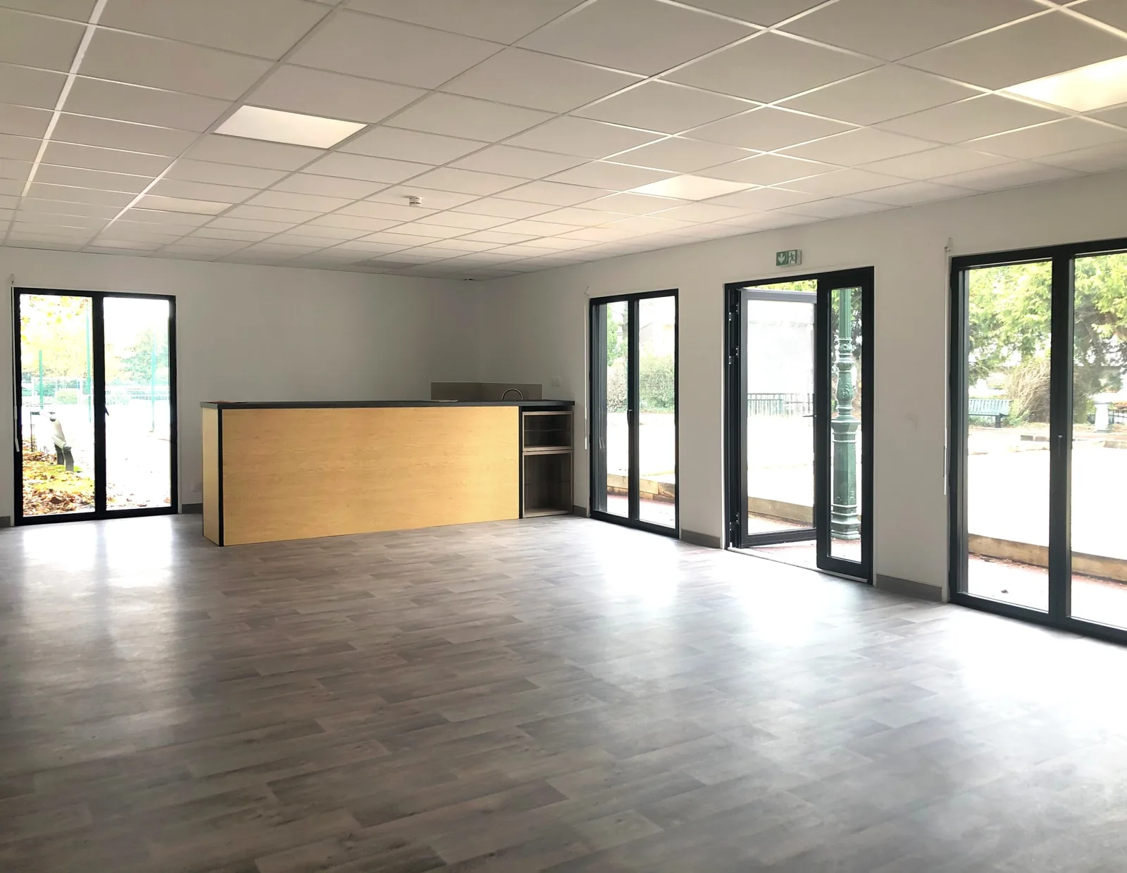 Salle du club des boulistes à Clamart avec comptoir et grandes baies vitrées
