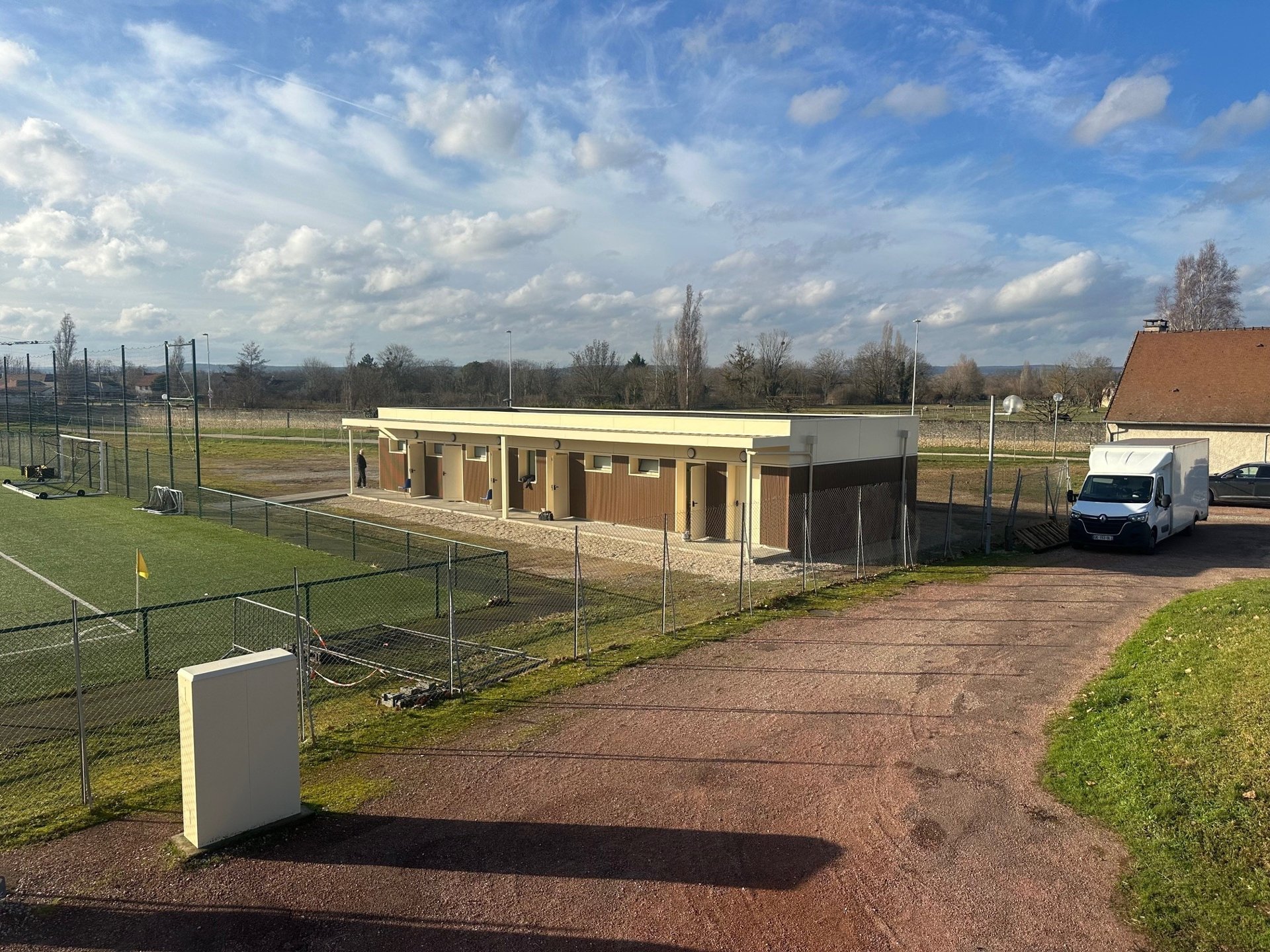 Vue générale des vestiaires modulaires de Vignoles pour la Mairie de Beaune, avec auvent près du terrain de football